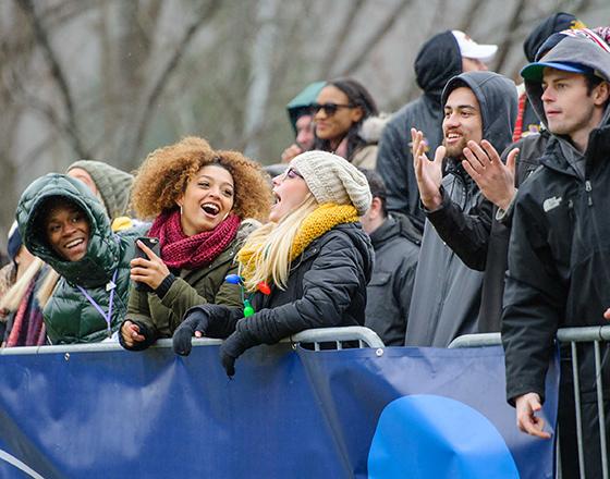 Group of students cheering on an athletic event outside